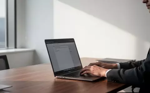 Ein minimalistischer, moderner Arbeitsplatz mit einem Laptop in einem hellen Bürogebäude bei natürlichem Tageslicht. - Foto: über boerse-global.de