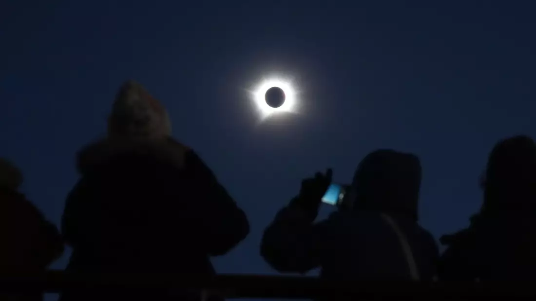 Passagiere schauen auf die totale Sonnenfinsternis an Bord des Kreuzfahrtschiffs „Ambition“ der Reederei Ambassador vor der Küste Grönlands. - Bild: Owen Humphreys/PA Wire/dpa