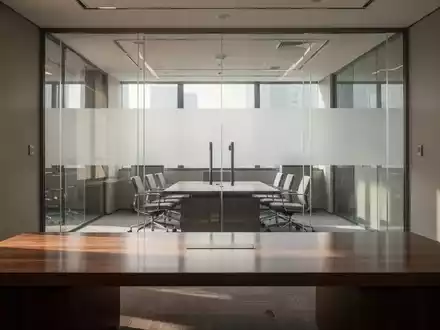 Ein minimalistisches, modern eingerichtetes Büro mit einer Glaswand in einem Konferenzraum bei natürlichem Lichteinfall. - Foto: über boerse-global.de