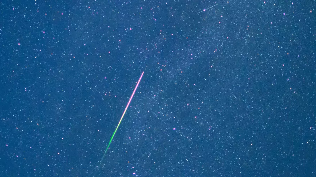 Ein Meteor mit grünem Schweif ist in der Nacht zu Donnerstag am Sternenhimmel zu sehen.  - Bild: Patrick Pleul/dpa