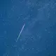 Ein Meteor mit grünem Schweif ist in der Nacht zu Donnerstag am Sternenhimmel zu sehen.  - Bild: Patrick Pleul/dpa