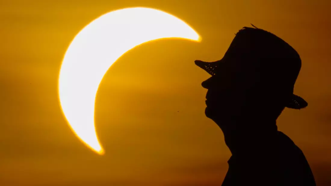 Ein Mann betrachtet die partielle Sonnenfinsternis im östlichen Brandenburg. - Bild: Patrick Pleul/dpa