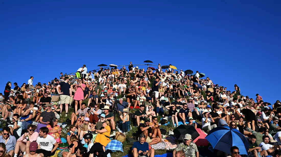 Menschen betrachten eine partielle Sonnenfinsternis am Olympiaberg im Münchner Olympiapark.  - Bild: Felix Hörhager/dpa