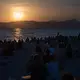Menschen sitzen am Strand von Palma und warten auf die totale Sonnenfinsternis. - Bild: Clara Margais/dpa