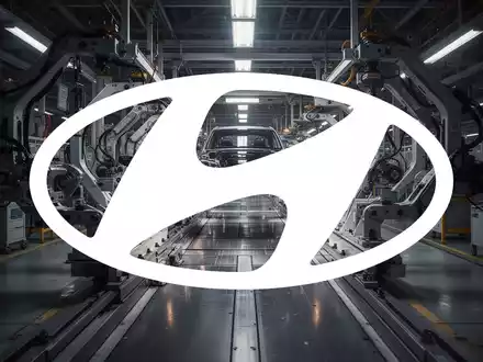 Moderne, düster beleuchtete Fabrikhalle einer Automobilproduktion als Symbol für industrielle Herausforderungen. - Foto: über boerse-global.de