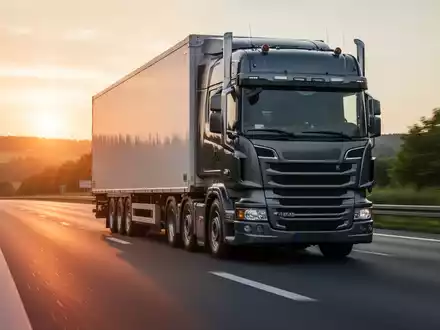 Ein schwerer Lastkraftwagen fährt bei Sonnenuntergang auf einer deutschen Autobahn. - Foto: über boerse-global.de