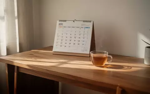 Ein minimalistischer, lichtdurchfluteter Arbeitsplatz mit einem analogen Kalender und einer Teetasse, der Ruhe ausstrahlt. - Foto: über boerse-global.de