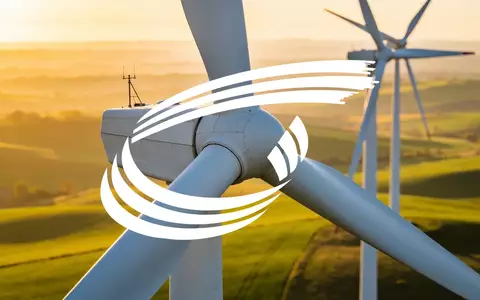 Moderne Windkraftanlagen in einer weiten Landschaft bei Sonnenaufgang als Symbol für erneuerbare Energien. - Foto: über boerse-global.de