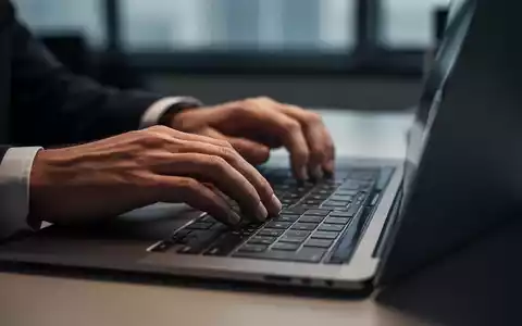 Nahaufnahme einer Person, die an einem Laptop in einem professionell beleuchteten Büro arbeitet. - Foto: über boerse-global.de