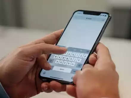 Nahaufnahme einer Hand, die ein iPhone bedient, um Text auf der Tastatur einzugeben. - Foto: über boerse-global.de