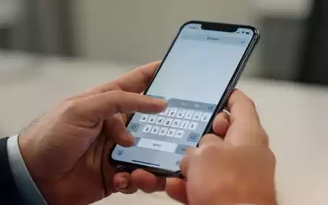 Nahaufnahme einer Hand, die ein iPhone bedient, um Text auf der Tastatur einzugeben. - Foto: über boerse-global.de