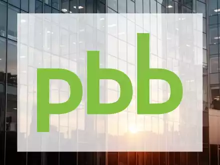 Moderne Glasfassade eines Bürogebäudes im goldenen Morgenlicht als Symbol für wirtschaftliche Erholung und Stabilität. - Foto: über boerse-global.de