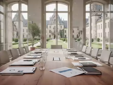 Ein heller Konferenzraum in einem Schloss mit einem langen Holztisch, bereit für politische Beratungen bei Tageslicht. - Foto: über boerse-global.de
