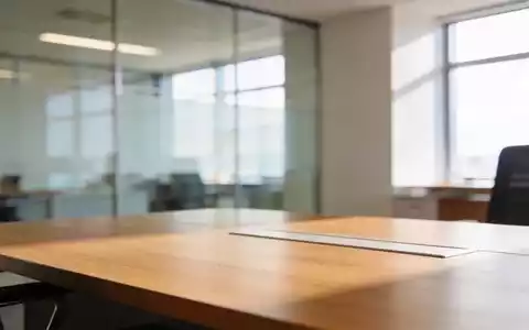 Ein heller, moderner Büroarbeitsplatz mit einem Schreibtisch vor einer Glasfront, der eine professionelle Atmosphäre vermittelt. - Foto: über boerse-global.de