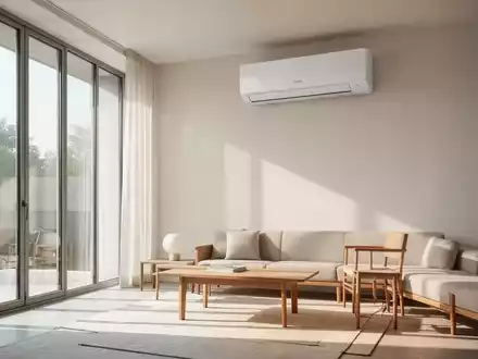 Ein minimalistisch eingerichtetes Wohnzimmer mit einem dezent an der Wand montierten, modernen Klimagerät. - Foto: über boerse-global.de
