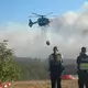 Ein Löschhubschrauber fliegt an. - Bild: Christoph Driessen/dpa