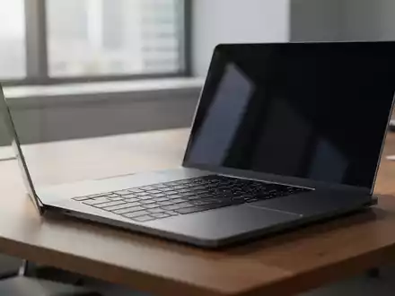 Ein moderner, aufgeräumter Arbeitsplatz mit einem aufgeklappten Laptop auf einem Holztisch bei natürlichem Tageslicht. - Foto: über boerse-global.de