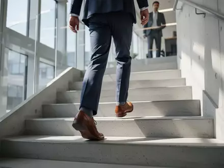 Eine Person in Business-Kleidung beim Treppensteigen in einem modernen Bürogebäude. - Foto: über boerse-global.de