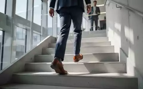 Eine Person in Business-Kleidung beim Treppensteigen in einem modernen Bürogebäude. - Foto: über boerse-global.de