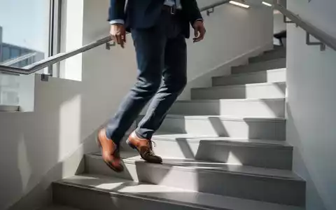 Eine Person geht in einem hellen Treppenhaus die Stufen hinauf, um sich sportlich zu betätigen. - Foto: über boerse-global.de