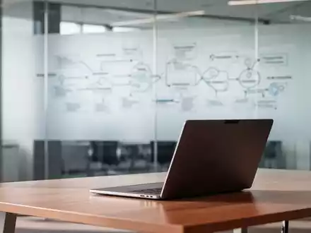 Ein moderner, heller Büroarbeitsplatz mit einem Laptop auf einem Schreibtisch in einer professionellen Arbeitsumgebung. - Foto: über boerse-global.de