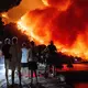 Menschen beobachten am frühen Freitag, dem 14. August 2026, einen Waldbrand an der Adriaküste in der Nähe von Omis im Süden Kroatiens. - Bild: Tom Dubravec/AP/dpa