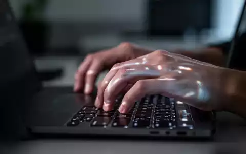 Nahaufnahme einer Person, die nervös an einem Laptop arbeitet, in einer modern beleuchteten Arbeitsumgebung. - Foto: über boerse-global.de