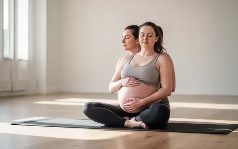 Eine schwangere Frau praktiziert in einem hellen, ruhigen Yoga-Studio achtsame Yoga-Übungen zur Entspannung. - Foto: über boerse-global.de