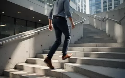 Eine Person geht in Bürokleidung zügig eine Treppe in einem modernen Gebäude hinauf. - Foto: über boerse-global.de
