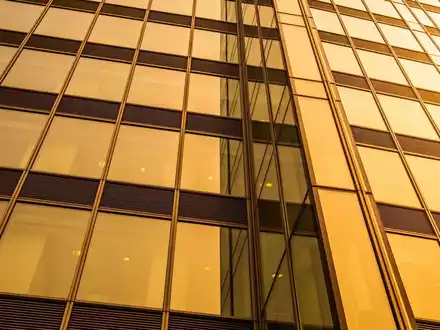 Moderne Glasfassade eines Bürogebäudes im Finanzviertel bei Sonnenuntergang. - Foto: über boerse-global.de