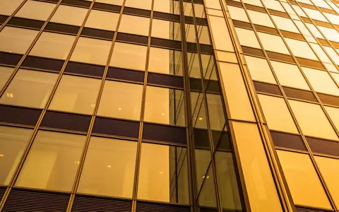 Moderne Glasfassade eines Bürogebäudes im Finanzviertel bei Sonnenuntergang. - Foto: über boerse-global.de