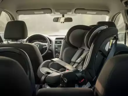Ein leerer Kindersitz auf der Rückbank eines Autos bei natürlichem Tageslicht. - Foto: über boerse-global.de