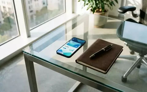 Ein moderner Schreibtisch mit einem Smartphone, einem Notizbuch und einem Füllfederhalter bei natürlichem Tageslicht. - Foto: über boerse-global.de