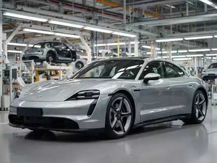 Ein silberner Porsche Taycan in einer modernen Montagehalle des Porsche-Stammwerks in Stuttgart-Zuffenhausen. - Foto: über boerse-global.de