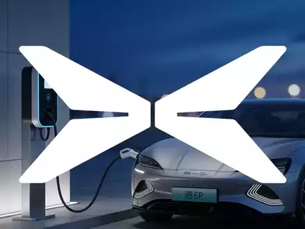 Moderne E-Auto-Ladestation in einer urbanen Umgebung bei Dämmerung, symbolisiert den Wandel in der Automobilbranche. - Foto: über boerse-global.de