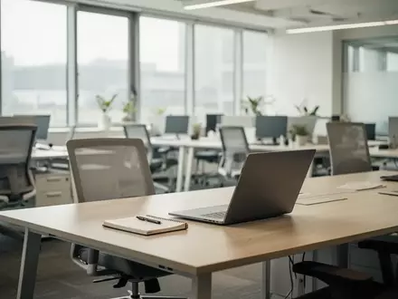 Ein heller, moderner Büroarbeitsplatz mit leerem Schreibtisch und natürlichem Tageslicht in einer professionellen Umgebung. - Foto: über boerse-global.de