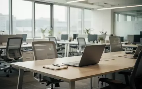 Ein heller, moderner Büroarbeitsplatz mit leerem Schreibtisch und natürlichem Tageslicht in einer professionellen Umgebung. - Foto: über boerse-global.de