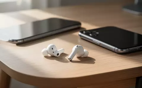 Weiße kabellose Kopfhörer liegen neben einem Smartphone auf einem minimalistischen Schreibtisch. - Foto: über boerse-global.de