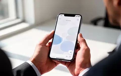 Eine Person hält ein modernes Smartphone in einem hellen Büro, wobei der Fokus auf dem Gerät und der Hand liegt. - Foto: über boerse-global.de