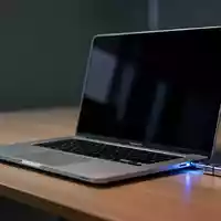 Ein silberner Laptop auf einem minimalistischen Schreibtisch in einem Büro mit gedimmtem Licht. - Foto: über boerse-global.de