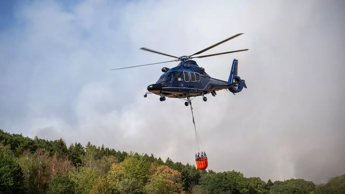 Etwa zehn Löschhubschrauber kommen bei der Brandbekämpfung im Hürtgenwald zum Einsatz. - Bild: Harald Tittel/dpa