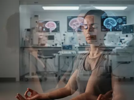 Eine Person meditiert in einem ruhigen Raum, während im unscharfen Hintergrund medizinische Laborausrüstung angedeutet ist. - Foto: über boerse-global.de