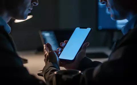 Eine Person betrachtet in einem abgedunkelten Raum ein Smartphone, während das Licht des Bildschirms ihr Gesicht beleuchtet. - Foto: über boerse-global.de