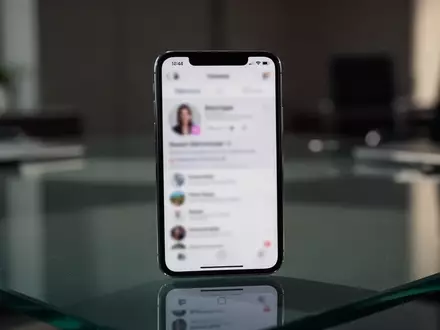 Ein Smartphone mit einer verschwommenen Social-Media-Benutzeroberfläche auf einem Schreibtisch in einem dunklen Büro. - Foto: über boerse-global.de