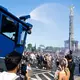 Ein Wasserwerfer der Polizei verschafft den Ravern etwas Abkühlung.   - Bild: Christophe Gateau/dpa