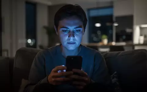 Eine Person betrachtet nachts in einer abgedunkelten Wohnung konzentriert den Bildschirm ihres Smartphones. - Foto: über boerse-global.de