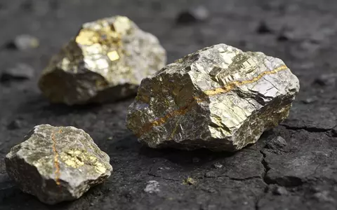 Nahaufnahme von uranhaltigem Gestein auf einem geologischen Arbeitstisch bei natürlichem Licht. - Foto: über boerse-global.de