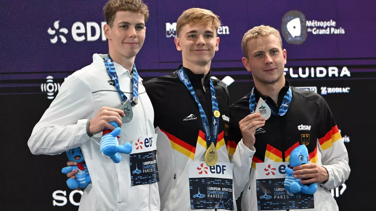 Zwei Deutsche freuen sich auf dem Podium. - Bild: Emma Da Silva/AP/dpa