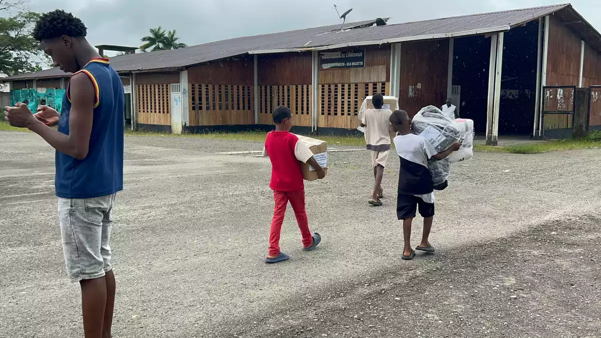 Kinder bringen die Pakete ins Dorf. - Bild: Philipp Znidar/dpa