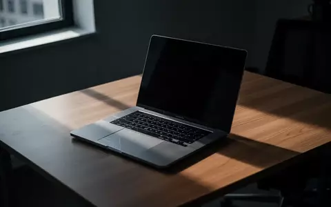 Ein Laptop auf einem dunklen Büroschreibtisch in einer nachdenklichen, atmosphärischen Lichtstimmung. - Foto: über boerse-global.de
